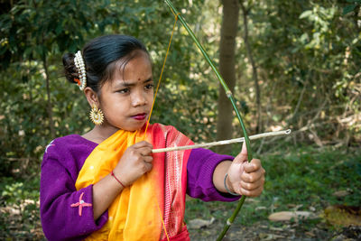 Side view of young woman holding plant