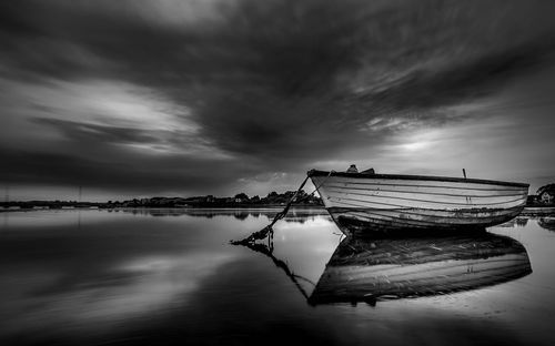 Pier on sea against cloudy sky