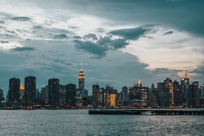 View of buildings at waterfront against cloudy sky