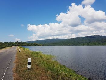 Road by lake against sky