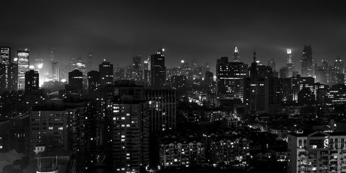 Illuminated cityscape against sky at night