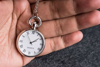 Close-up of hand holding pocket watch