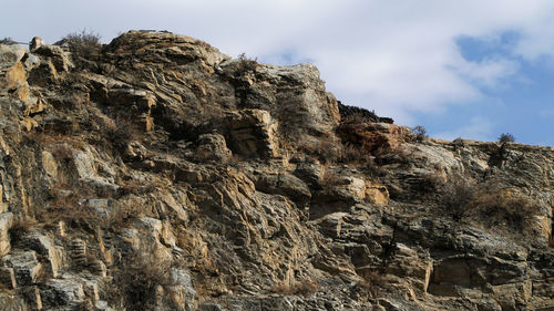 Low angle view of rock formation on land against sky