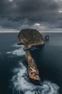 Rock formation in sea against sky