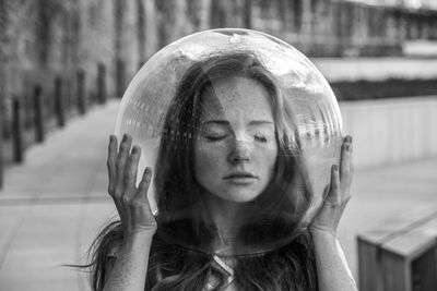 Young woman wearing glass helmet in head on sidewalk