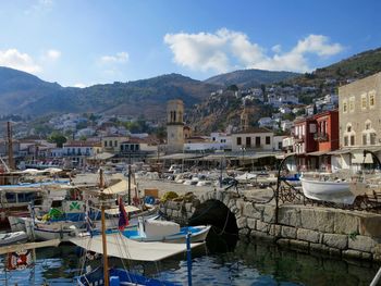 Boats moored in river against town