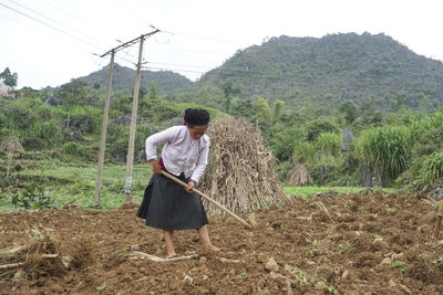 Rear view of woman walking on dirt road