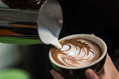 Close-up of hand holding coffee cup