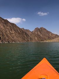 Scenic view of lake by mountains against sky