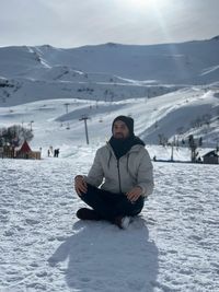 Man sitting on snowcapped mountain