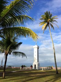 Historic, old lighthouse in a sea cliff by palm trees against sky in porto seguro, brazil