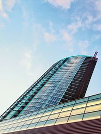 Low angle view of skyscraper against cloudy sky