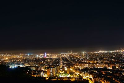 High angle view of illuminated cityscape against clear sky