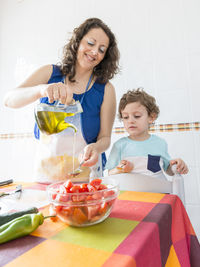 Close-up of woman and son preparing food