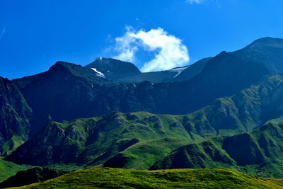 Scenic view of mountains against blue sky