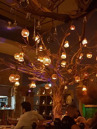 Low angle view of illuminated light bulbs hanging on ceiling