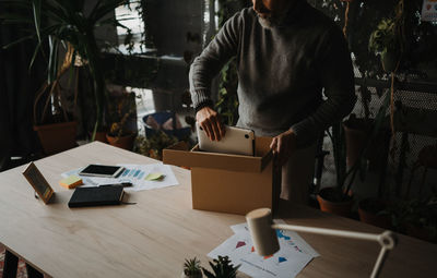 Mature employee packing his belongings and leaving the office