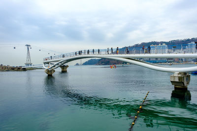 Bridge over river in city against sky