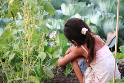 Rear view of woman with plants in park