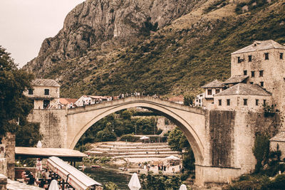 Arch bridge over buildings against mountain