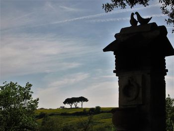 Statue by trees against sky