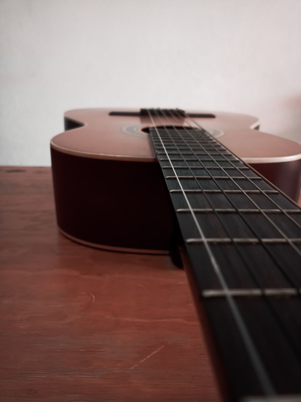 CLOSE-UP OF GUITAR WITH TABLE