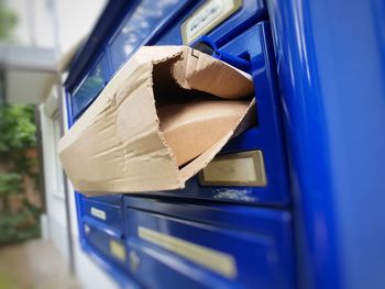 Close-up of cardboard on blue mailbox