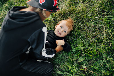 A girl in a hat and a skeleton costume plays with her younger brother on the grass in the garden. 