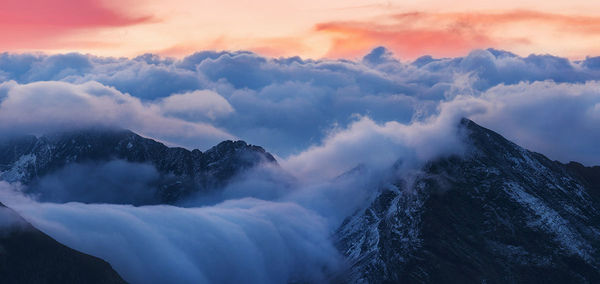 Scenic view of snowcapped mountains against sky during sunset