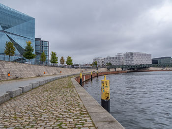 Bridge over river against cloudy sky