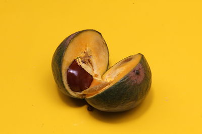 Close-up of avocado over yellow background