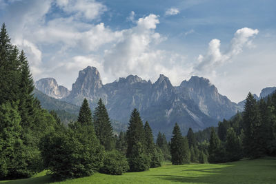 Scenic view of green landscape and mountains against sky
