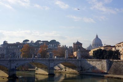 Bridge over river against sky in city