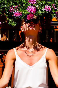 Midsection of woman standing by flowering plants