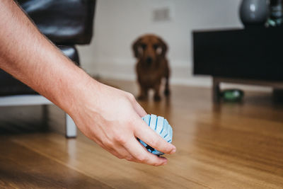 Close-up of man holding hands on table at home