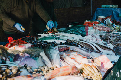 Midsection of vendor arranging fish for sale at market