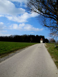 Empty road passing through field