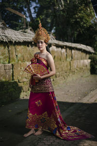 Portrait of young woman wearing traditional clothing standing on road