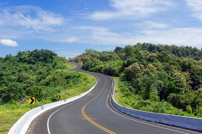 Road amidst trees against sky