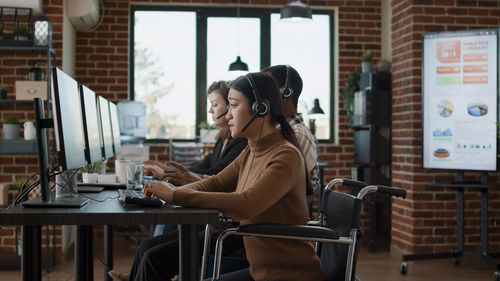 Side view of business colleagues talking on call in call center