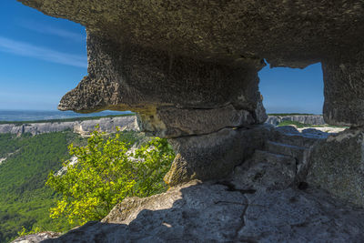 Rock formations by sea against sky