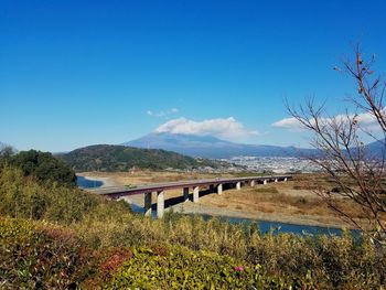 Panoramic view of bridge over landscape against blue sky