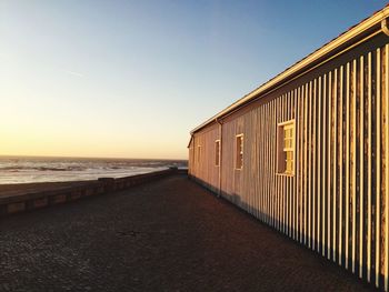 Scenic view of beach against clear sky during sunset