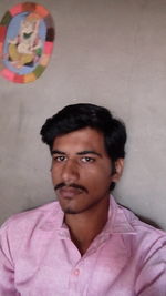 Portrait of young man against pink wall