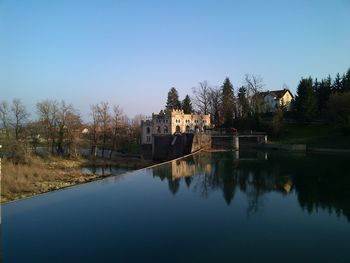 Reflection of trees in lake against clear sky