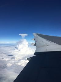Cropped image of airplane wing over cloudscape