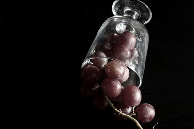 Close-up of grapes on table against black background