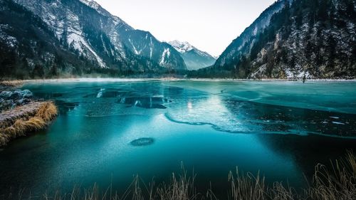 Swimming pool by lake against sky