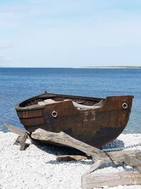 Abandoned boat moored on beach against clear sky