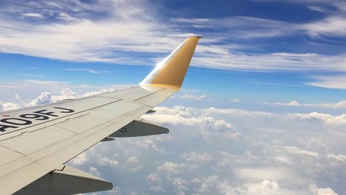 Cropped image of airplane flying over clouds